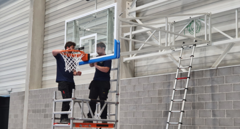 Techniciens Idema qui réparent un but de basket